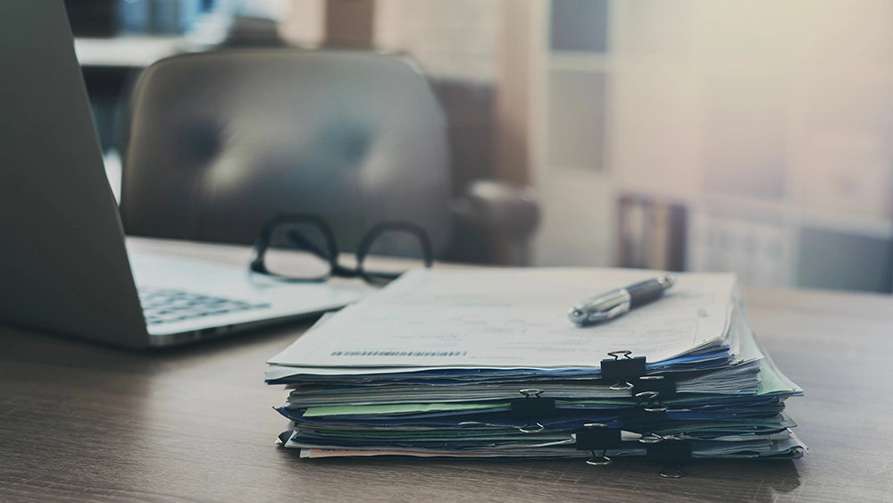 Stack of papers on wooden desk